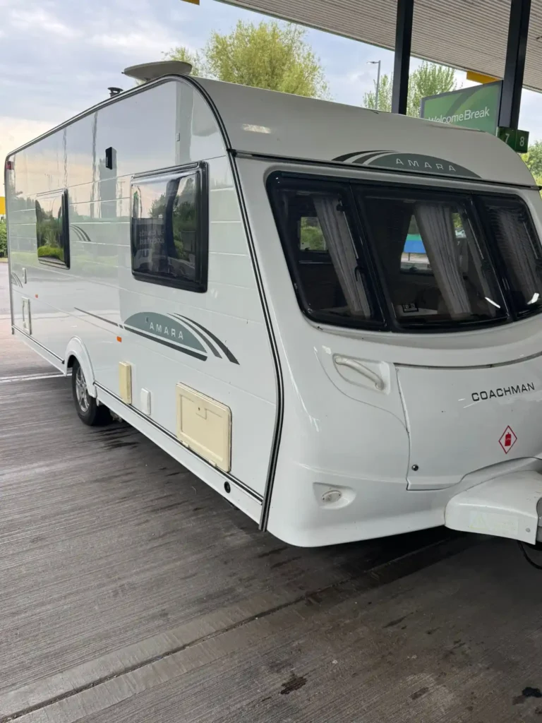 Touring caravan hitched to an estate car at a petrol station